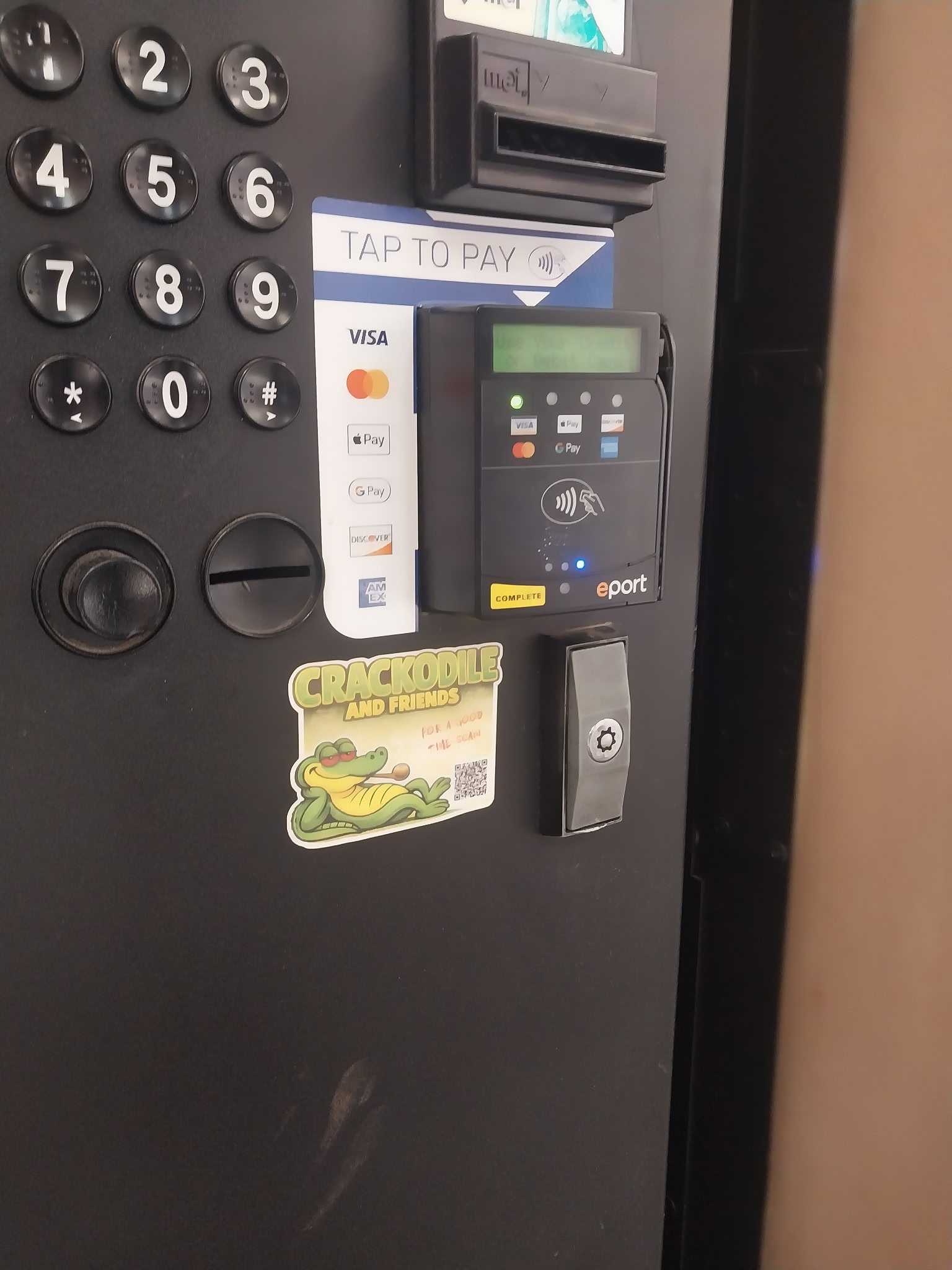 Crackodile and Friends sticker affixed to vending machine payment terminal, Philadelphia PA, April 2026